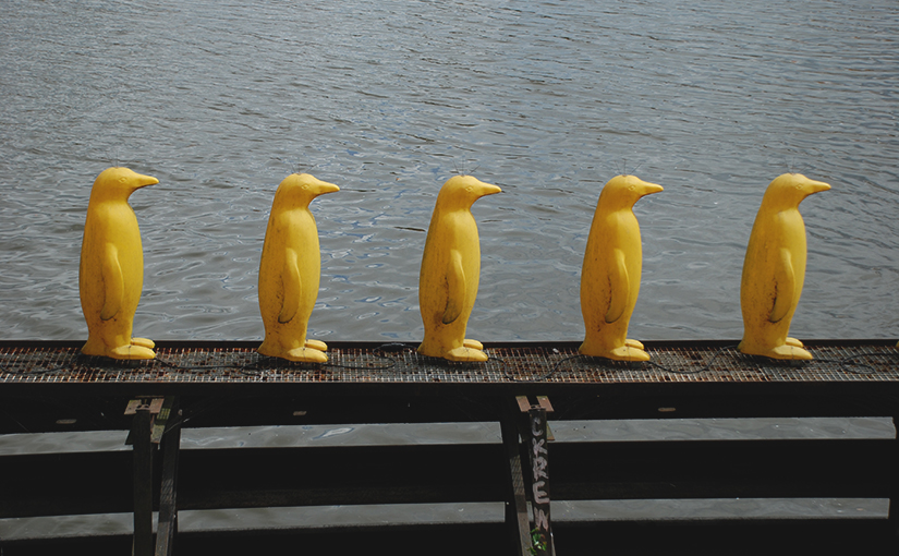 Eine Reihe von gelben Pinguinen aus Plastik