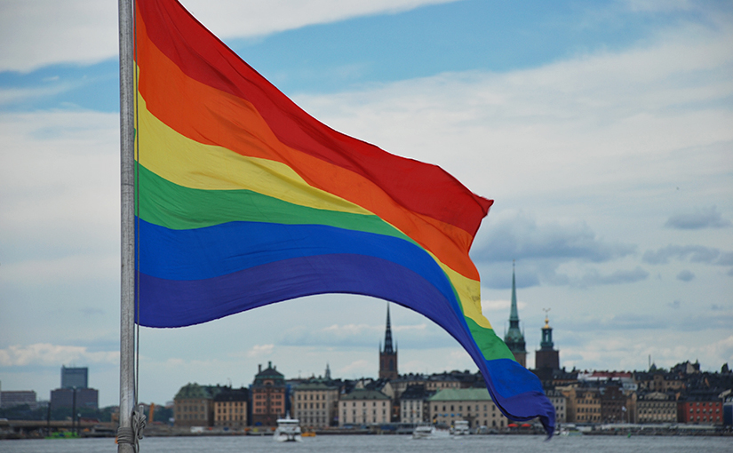 Regenbogenfahne, im Hintergrund Stockholm